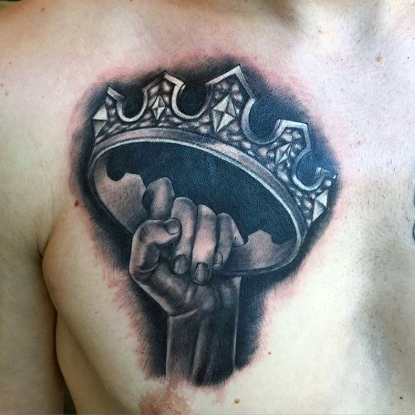Dark And Grey Crown In Hand Tattoo On Chest