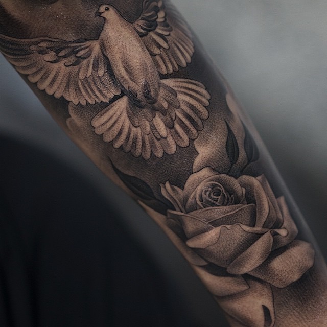 Flying Dove Tattoo With Grey Rose On Arm