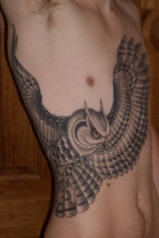 Grey Flying Owl Tattoo On Man Side Rib