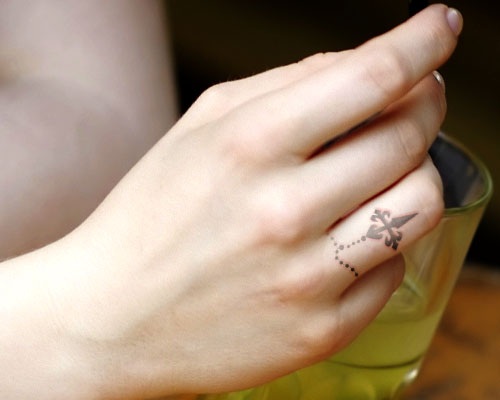 Grey Ink Cross Tattoo On Girl Finger