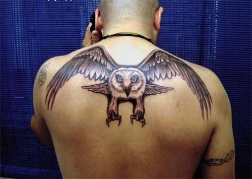 Grey Ink Flying Owl Tattoo On Man Upper Back