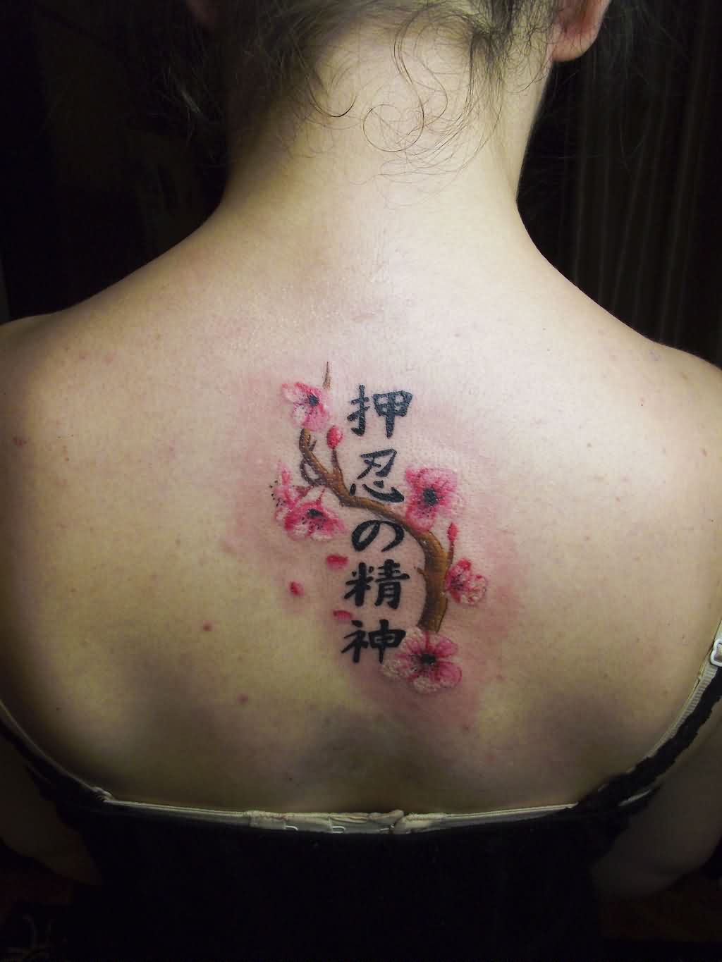 Kanji Symbols And Cherry Blossom Tattoo On Girl Upper Back