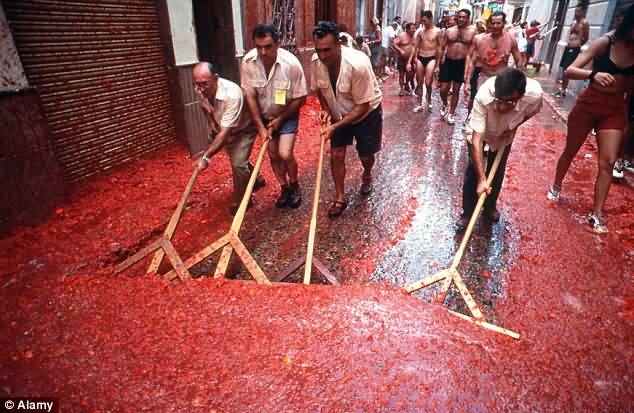 Local Residents Begin The Mammoth Clear Up Of Pulped Tomatoes After La Tomatina Festival Celebration