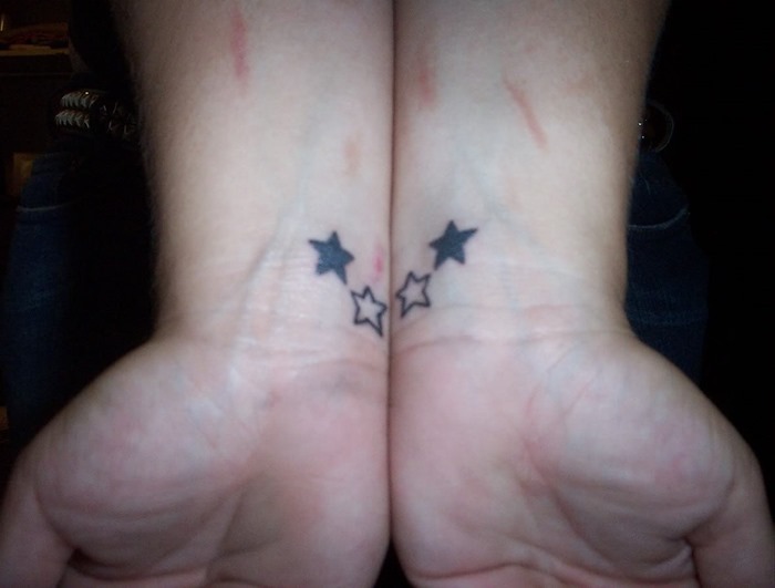 Man Showing His Star Tattoos On Wrists