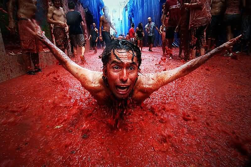 Man Sliding In Tomato Juice During La Tomatina Festival Celebration