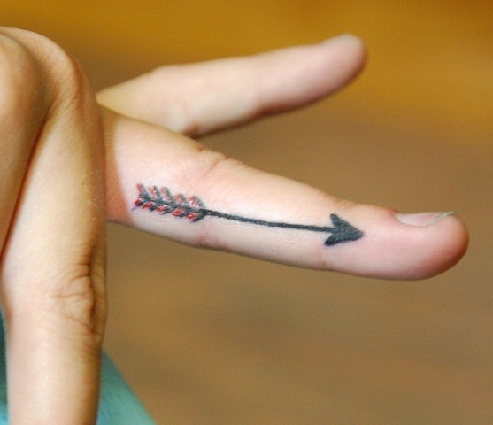 Red And Black Ink Arrow Side Finger Tattoo