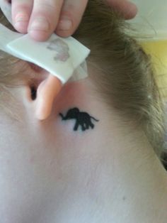 Silhouette Baby Elephant Tattoo On Left Behind The Ear