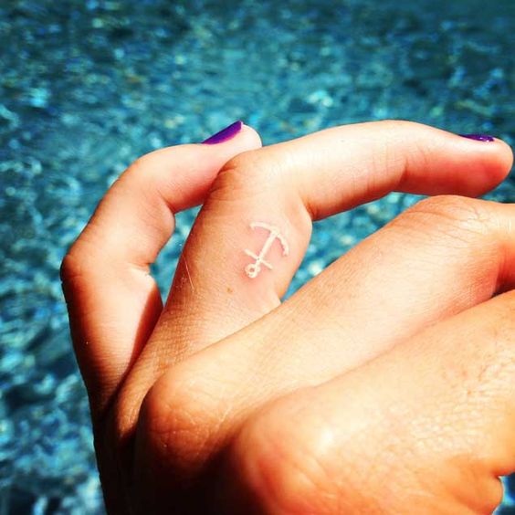 White Anchor Tattoo On Girl Side Finger