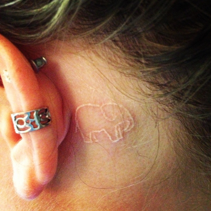 White Ink Elephant Tattoo On Girl Left Behind The Ear