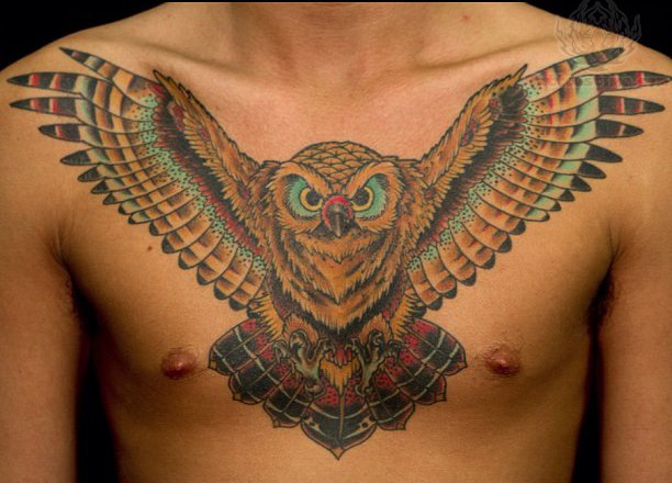 Attractive Colorful Flying Owl Tattoo On Man Chest
