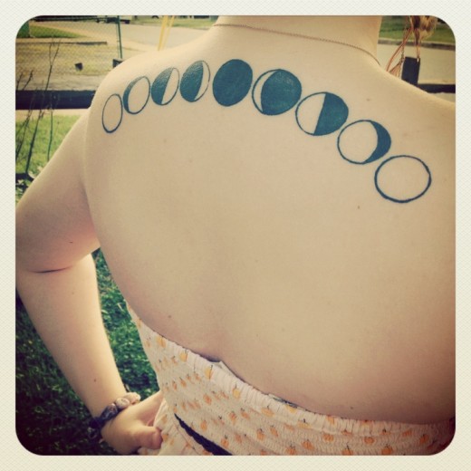 Awesome Black Ink Phases Of The Moon Tattoo On Girl Upper Back