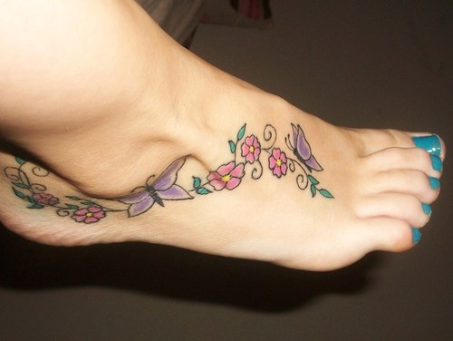 Awesome Red Flowers And Purple Ink Butterfly Tattoo On Foot