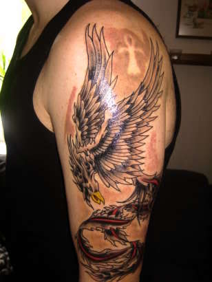 Black And Grey Flying Phoenix Tattoo On Man Left Upper Arm
