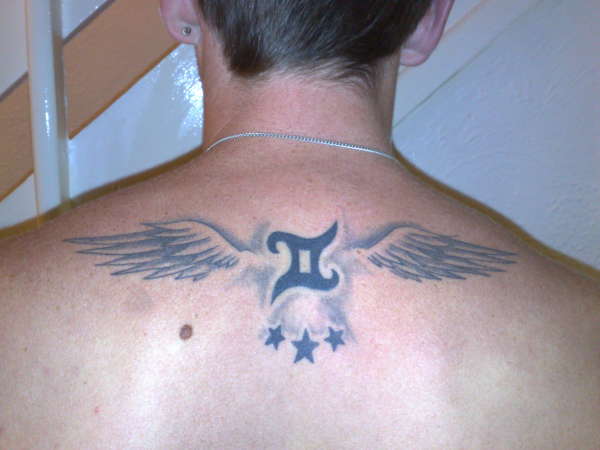 Black And Grey Gemini Zodiac Sign With Wings Tattoo On Man Upper Back