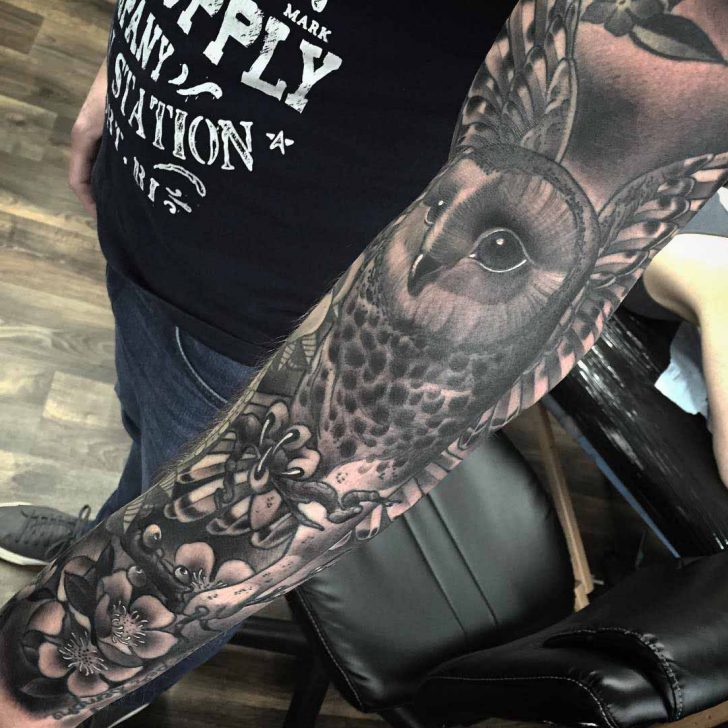 Black And Grey Owl With Flowers Tattoo On Man Left Full Sleeve