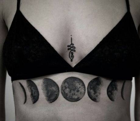 Black And Grey Phases Of The Moon Tattoo On Girl Under Chest