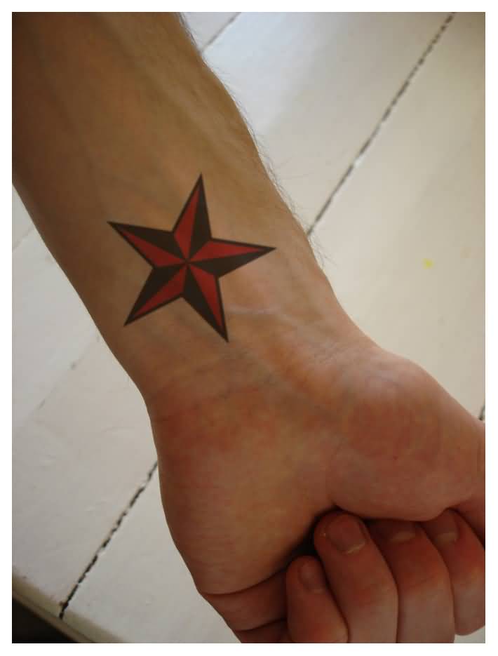 Black And Red Nautical Star Tattoo On Left Wrist