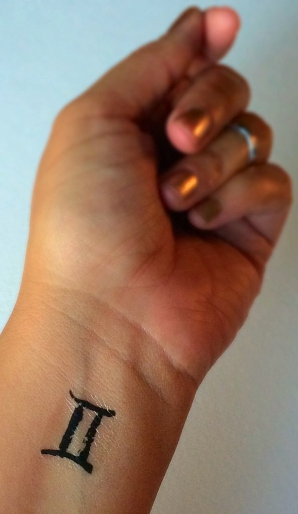 Black Gemini Zodiac Sign Tattoo On Girl Left Wrist