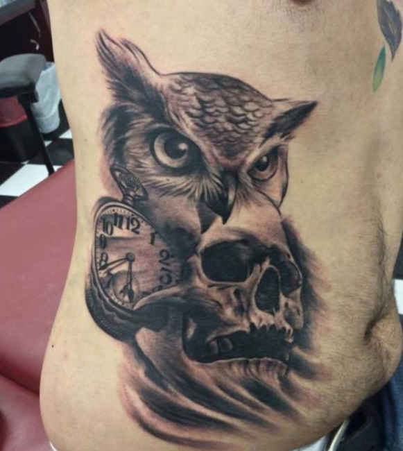 Black Ink 3D Owl Head With Skull And Clock Tattoo On Man Right Side Rib