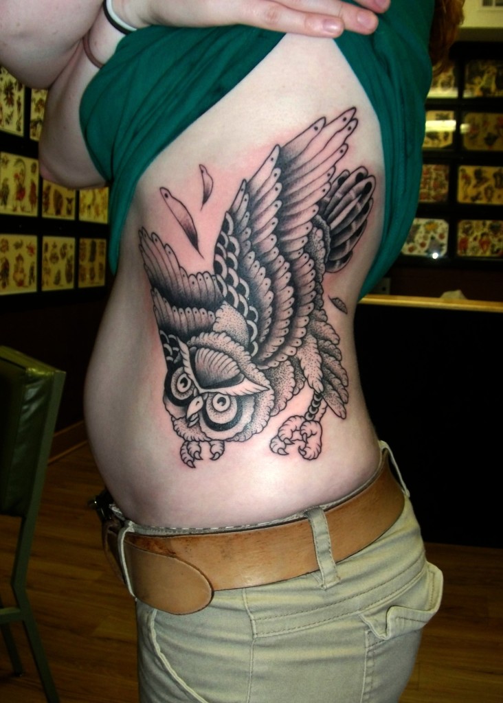 Black Ink Flying Owl Tattoo On Left Side Rib