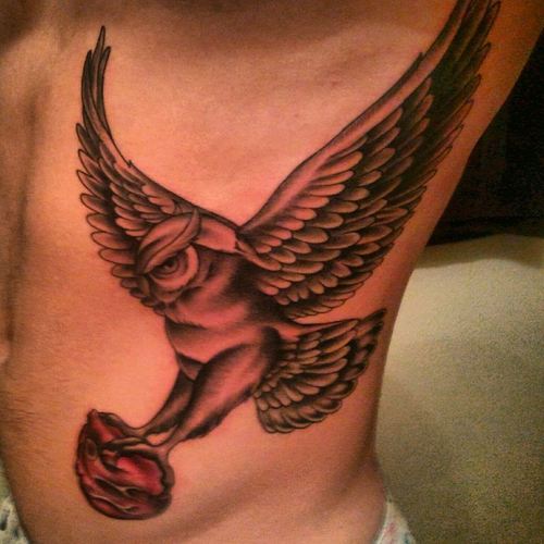 Black Ink Flying Owl Tattoo On Man Left Side Rib