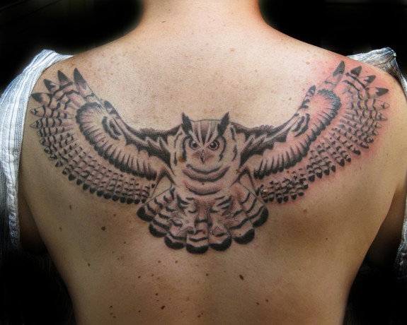 Black Ink Flying Owl Tattoo On Man Upper Back