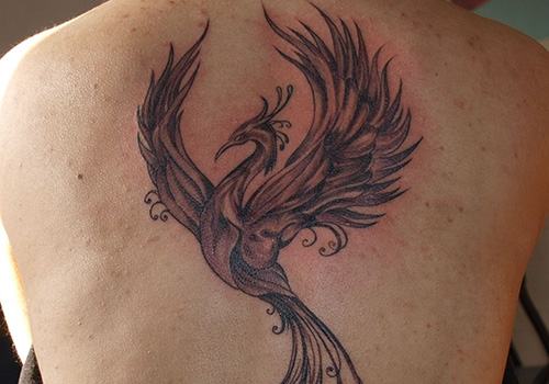 Black Ink Flying Phoenix Bird Tattoo On Upper Back