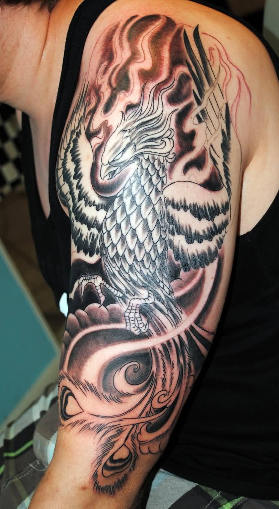 Black Ink Flying Phoenix Tattoo On Man Left Upper Arm By Charlie