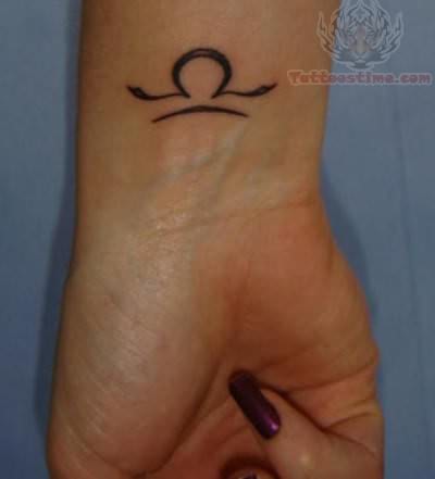 Black Ink Libra Zodiac Sign Tattoo On Girl Left Wrist