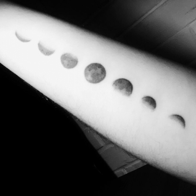 Black Ink Phases Of The Moon Tattoo On Arm