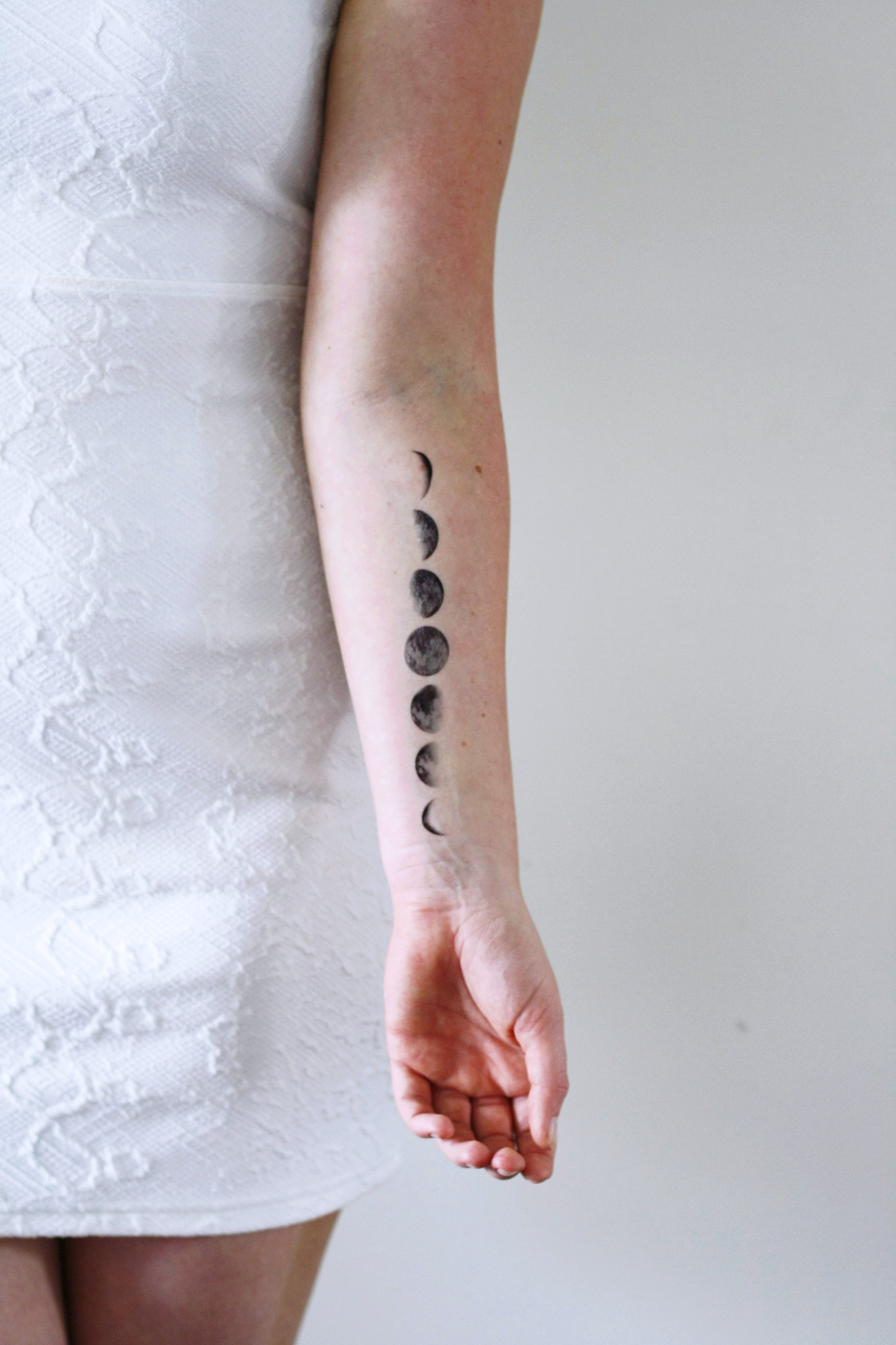 Black Ink Phases Of The Moon Tattoo On Girl Left Wrist By Wilma Boekkholts