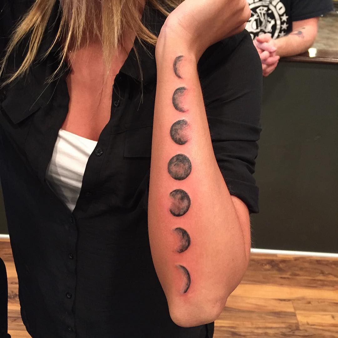 Black Ink Phases Of The Moon Tattoo On Left Arm