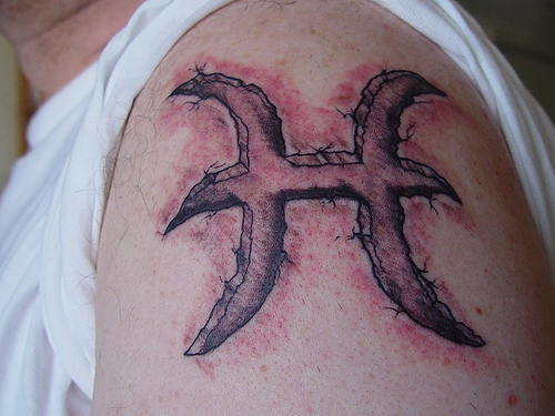 Black Ink Pisces Zodiac Sign Tattoo On Man Left Shoulder