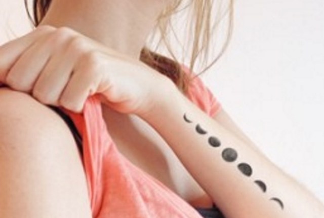 Black Ink Small Phases Of The Moon Tattoo On Girl Left Arm