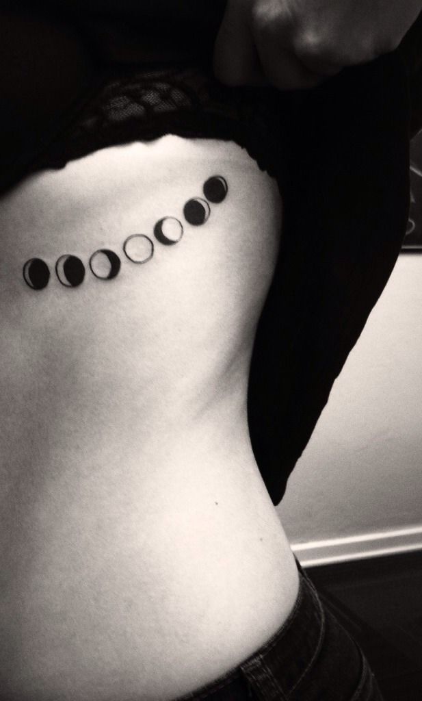 Black Ink Small Phases Of The Moon Tattoo On Girl Left Side Rib