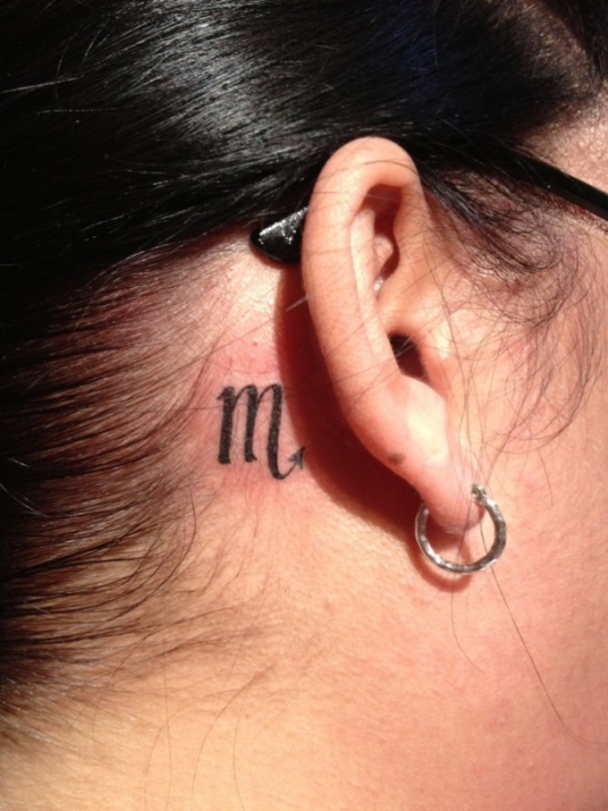Black Scorpio Zodiac Sign Tattoo On Girl Right Behind The Ear