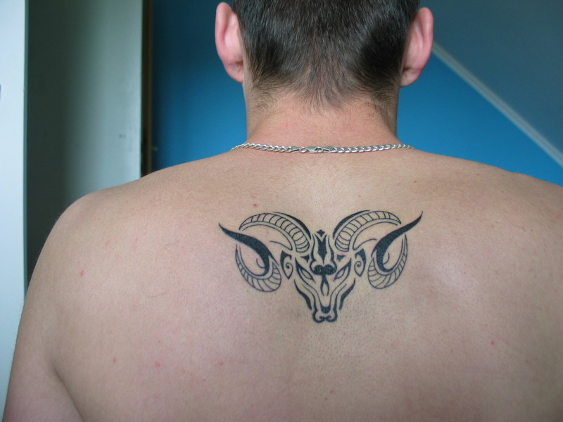 Black Tribal Aries Zodiac Sign Tattoo On Man Upper Back