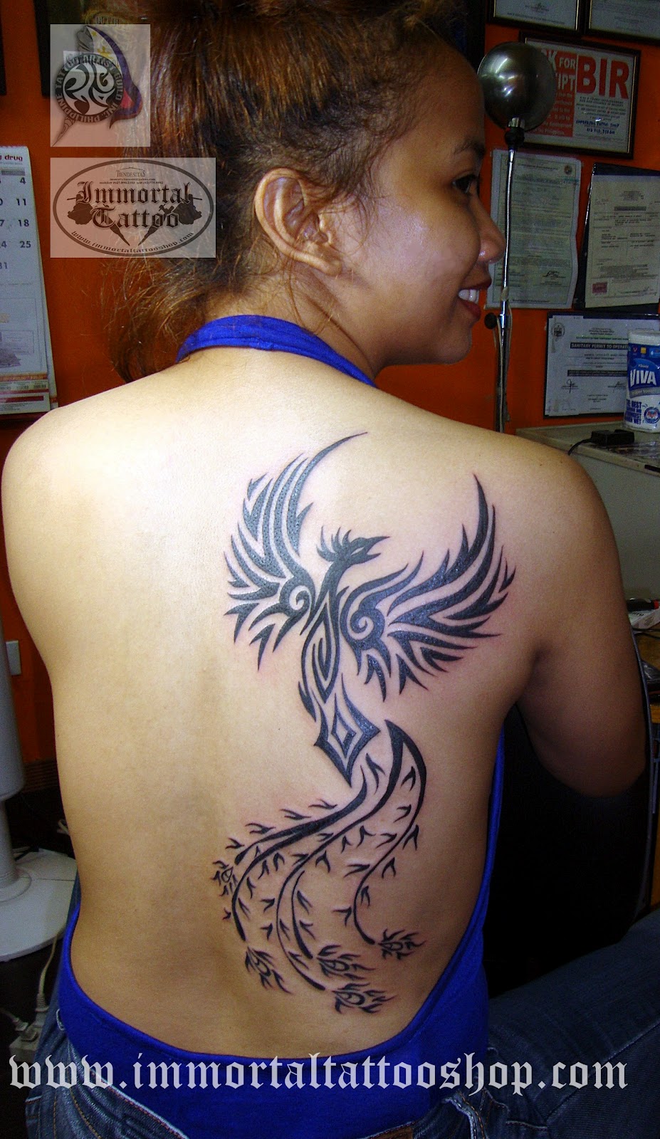 Black Tribal Phoenix Tattoo On Girl Upper Back