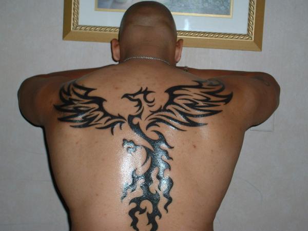 Black Tribal Phoenix Tattoo On Man Upper Back