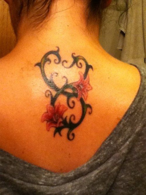 Black Tribal Taurus Zodiac Sign With Flowers Tattoo On Girl Upper Back