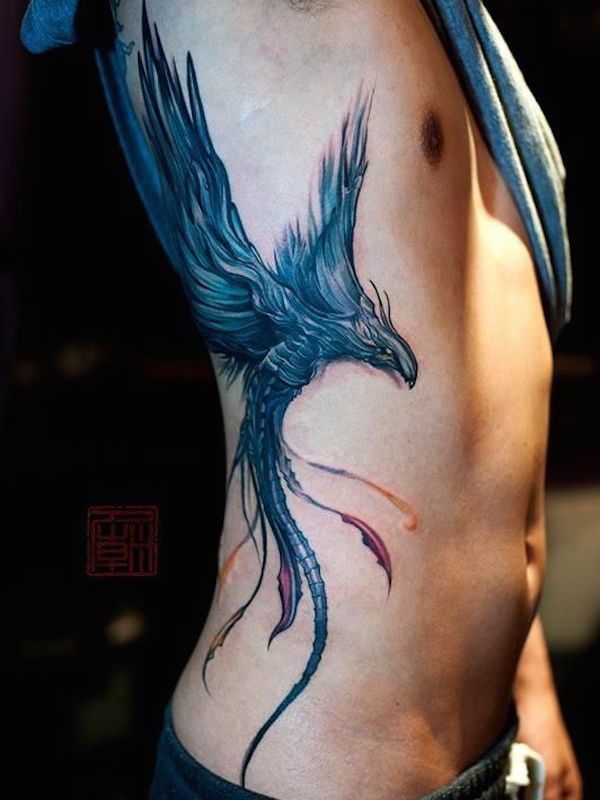 Blue Ink Flying Bird Tattoo On Man Right Side Rib