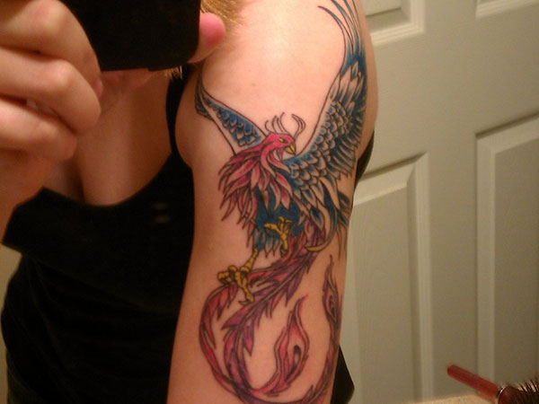 Colorful Flying Phoenix Tattoo On Girl Left Upper Arm