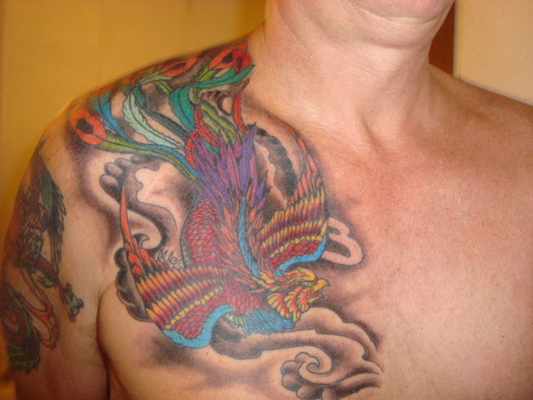 Colorful Flying Phoenix Tattoo On Man Right Chest