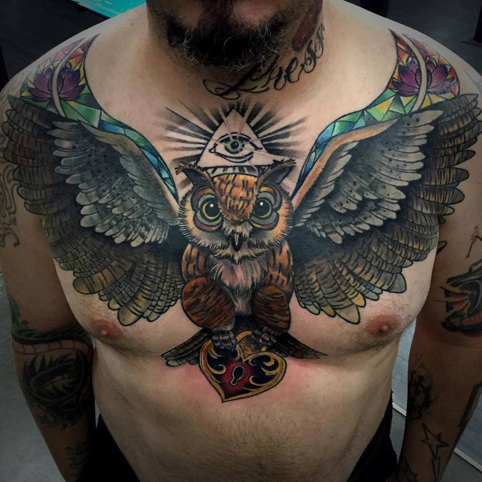 Cool Colorful Flying Owl With Heart Lock And Illuminati Eye Tattoo On Man Chest