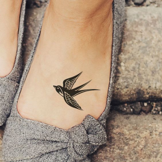 Cute Black Bird Tattoo On Girl Left Foot