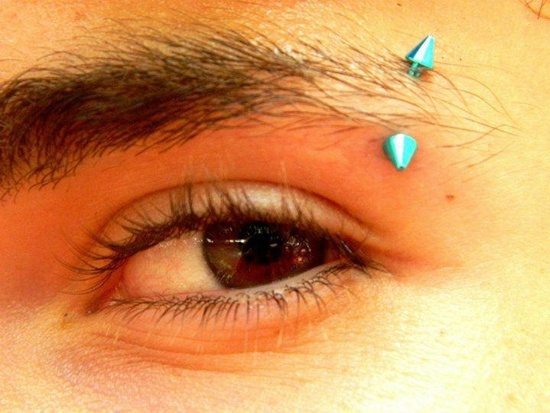 Eyebrow Piercing With Blue Spike Barbell