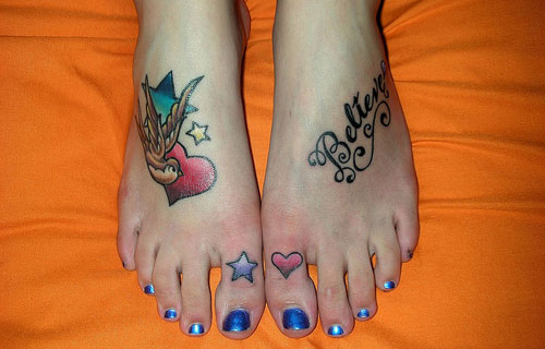 Flying Bird With Red Heart And Believe Tattoos On Both Feet