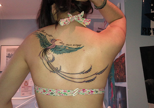 Flying Phoenix Bird Tattoo On Girl Upper Back