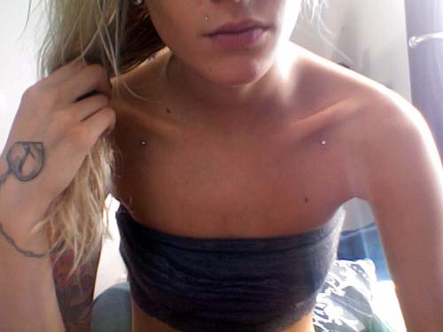 Girl Showing Her Clavicle Piercing With Dermals