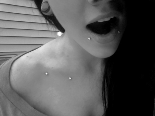 Girl With Lower Lip And Surface Clavicle Piercing
